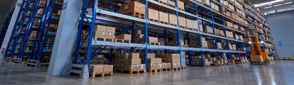Bodega industrial Nibec con racks metálicos azules y pallets de cajas